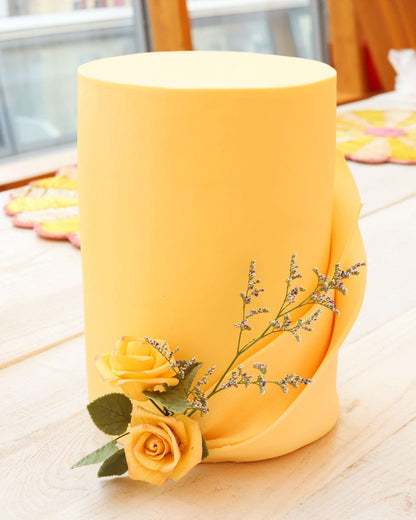 Elegant yellow rose cake with yellow rose sprig at the bottom