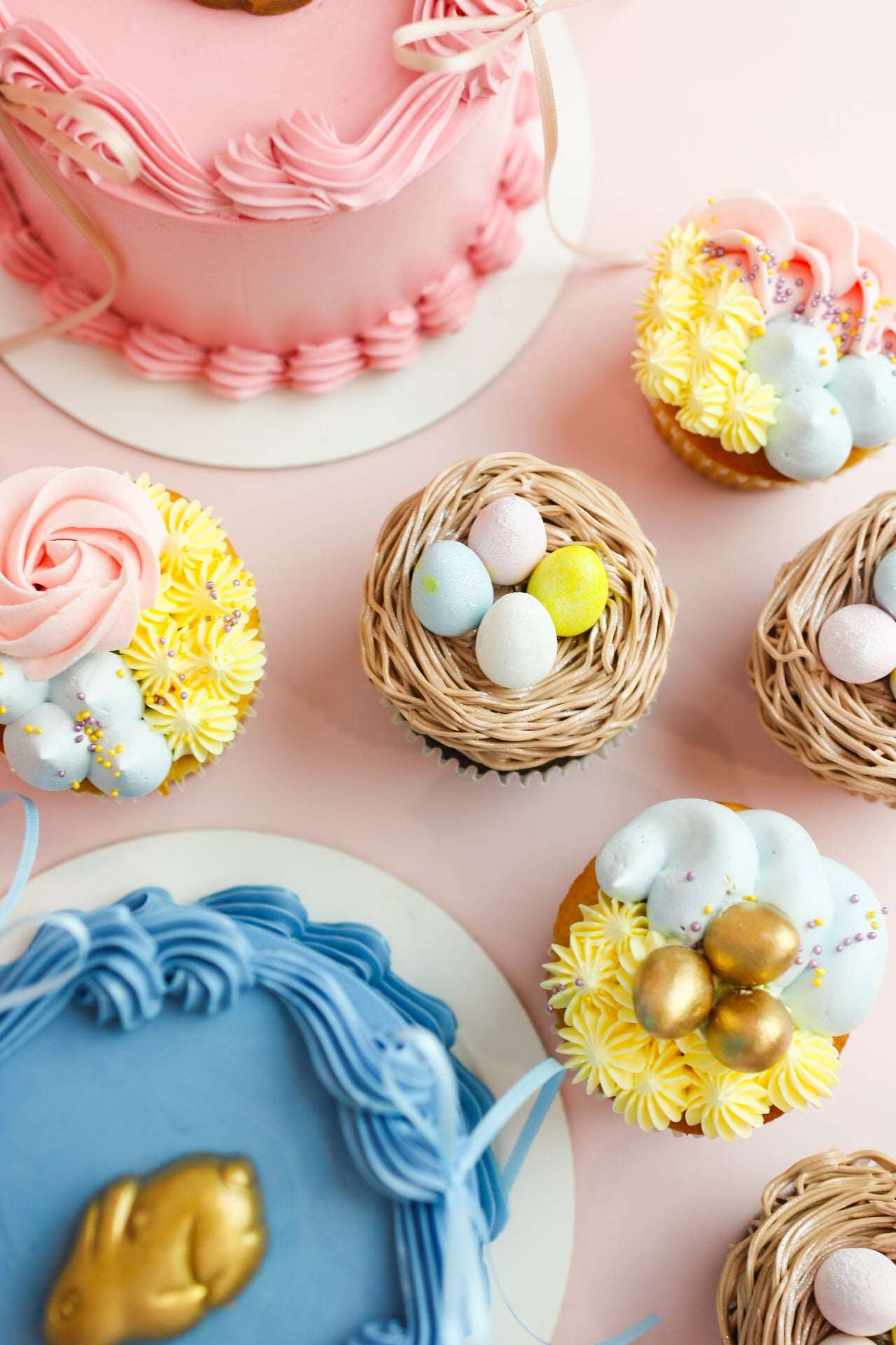Two Easter cakes and six cupcakes with decorative easter eggs