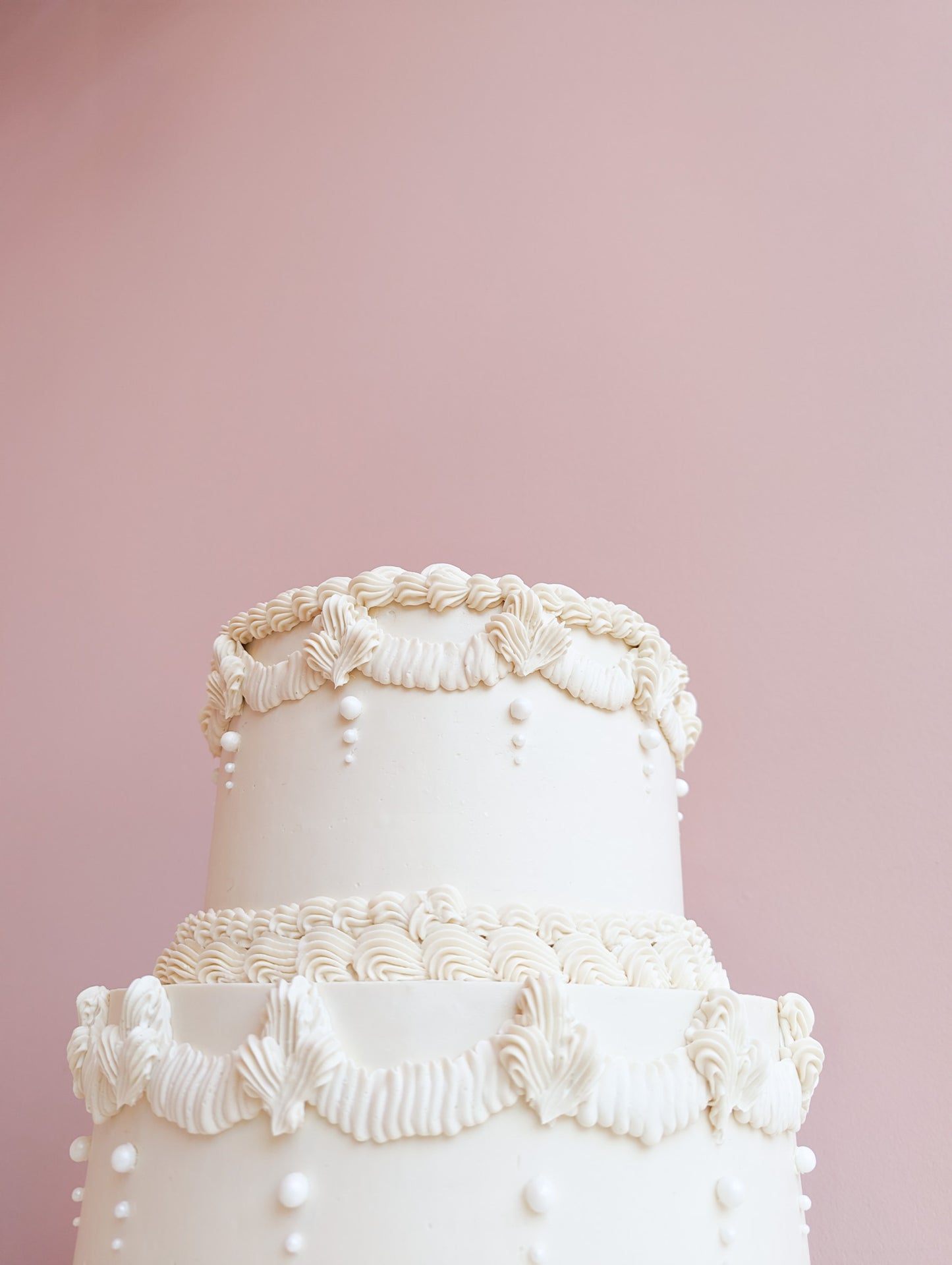 White tiered vintage cake with massive cream decor
