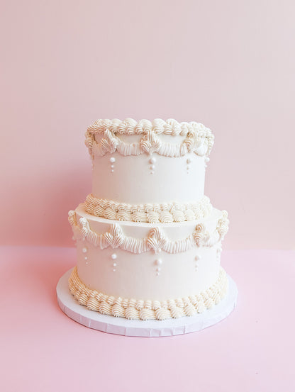 White tiered vintage cake with massive cream decor